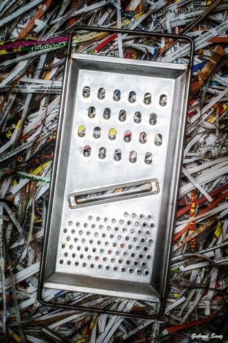 Composicion fotografico con rayador de alimentos sobre papel triturado