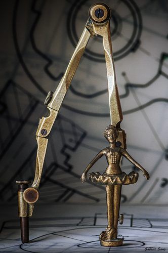 Bodegon conceptual, compas con figura de bailarina en eje